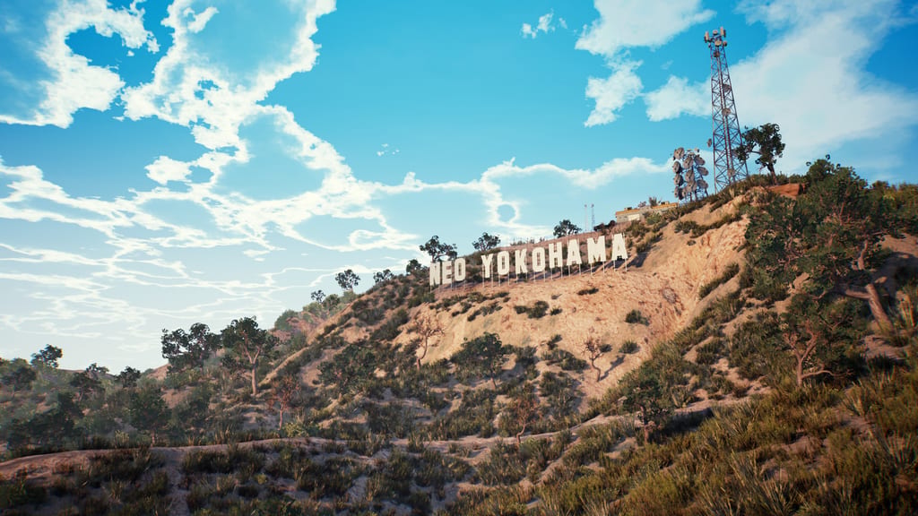 A hillside with a large white NEO YOKOHAMA sign styled like the Hollywood sign, under a bright blue sky