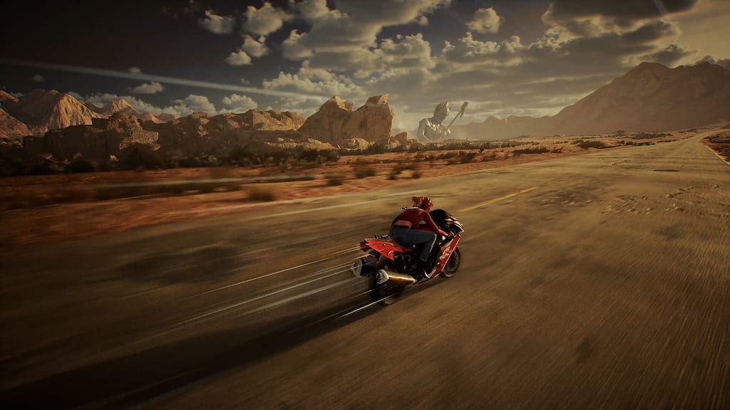 Choko, a red-haired young woman, speeding on a motorcycle down an empty desert highway past a giant weathered stone statue